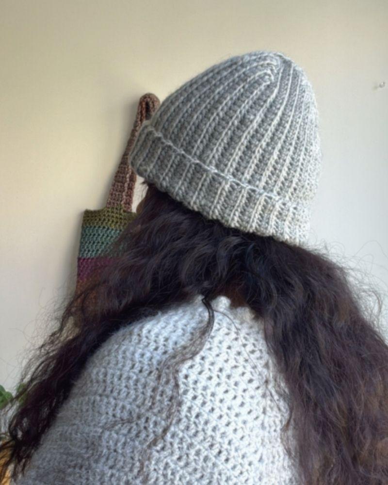 Person wearing a handmade beanie with a leather patch labeled 'Retro Foundry', Gray