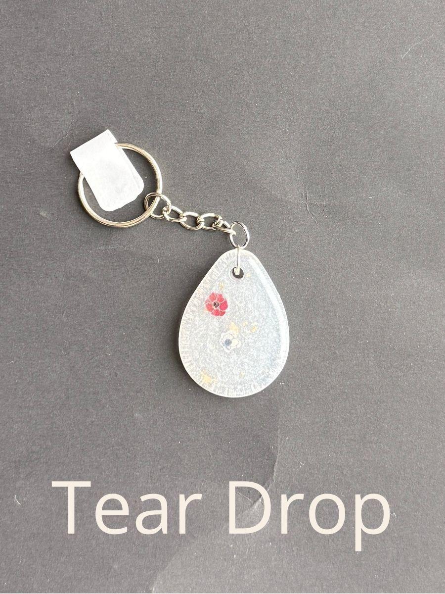 Tear Drop, keychain with floral design on a gray background