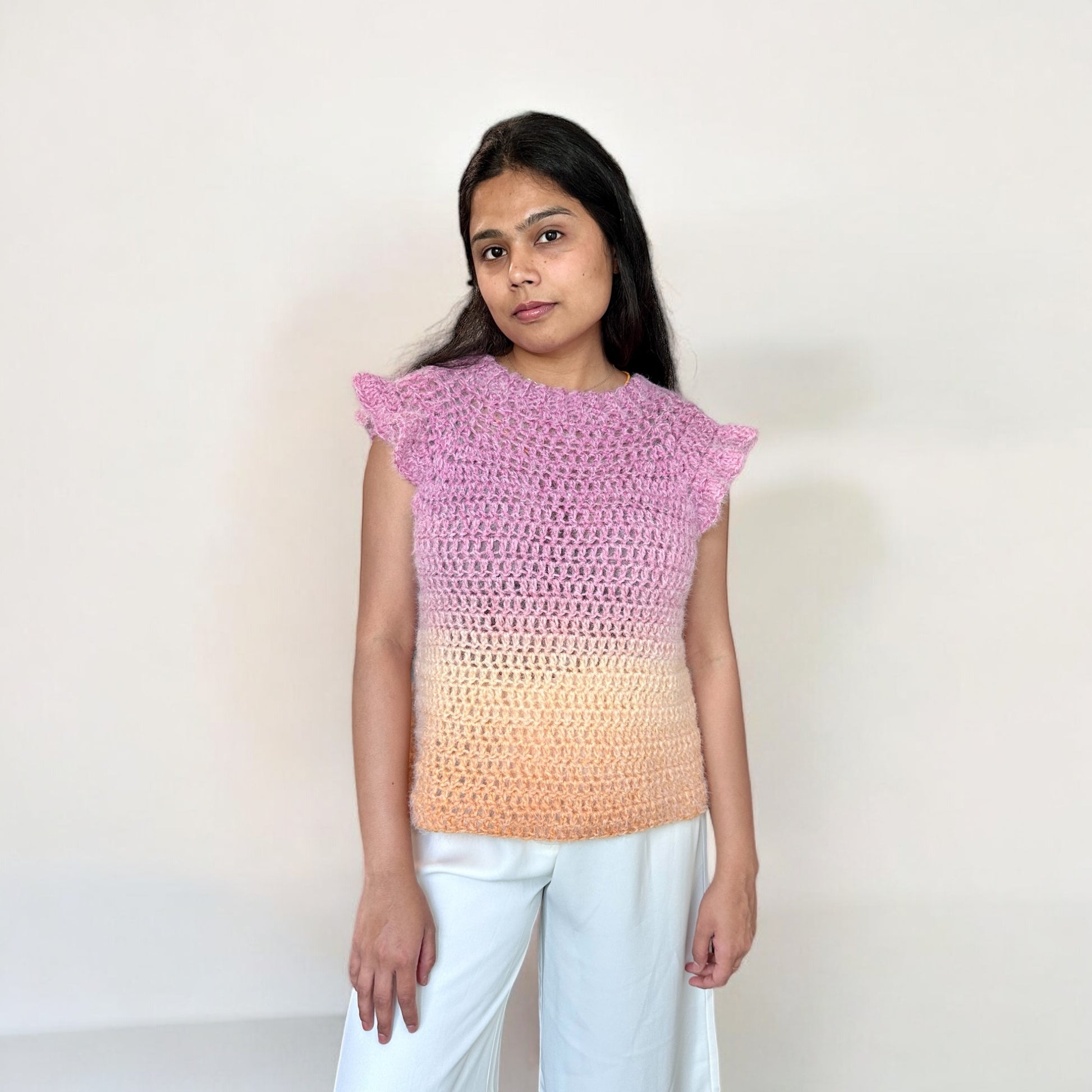 A girl wearing a crochet top-down blouse, highlighting the front design, neckline, and stitch pattern.