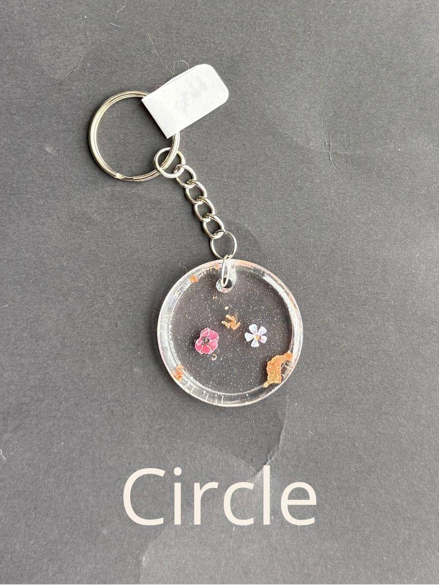 Circle, keychain with floral design on a gray background