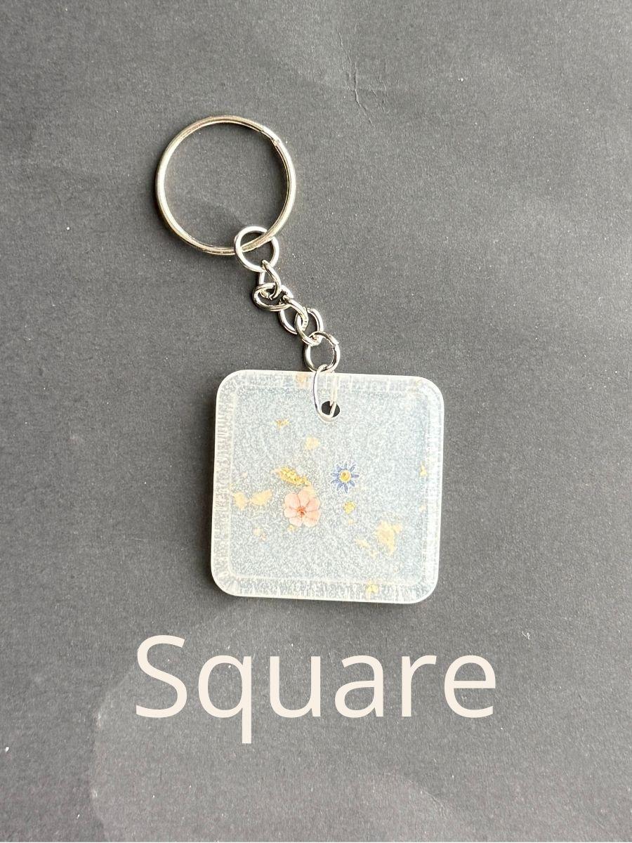 Square, keychain with floral design on a gray background