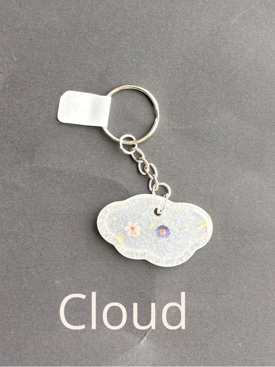 Cloud, keychain with floral design on a gray background