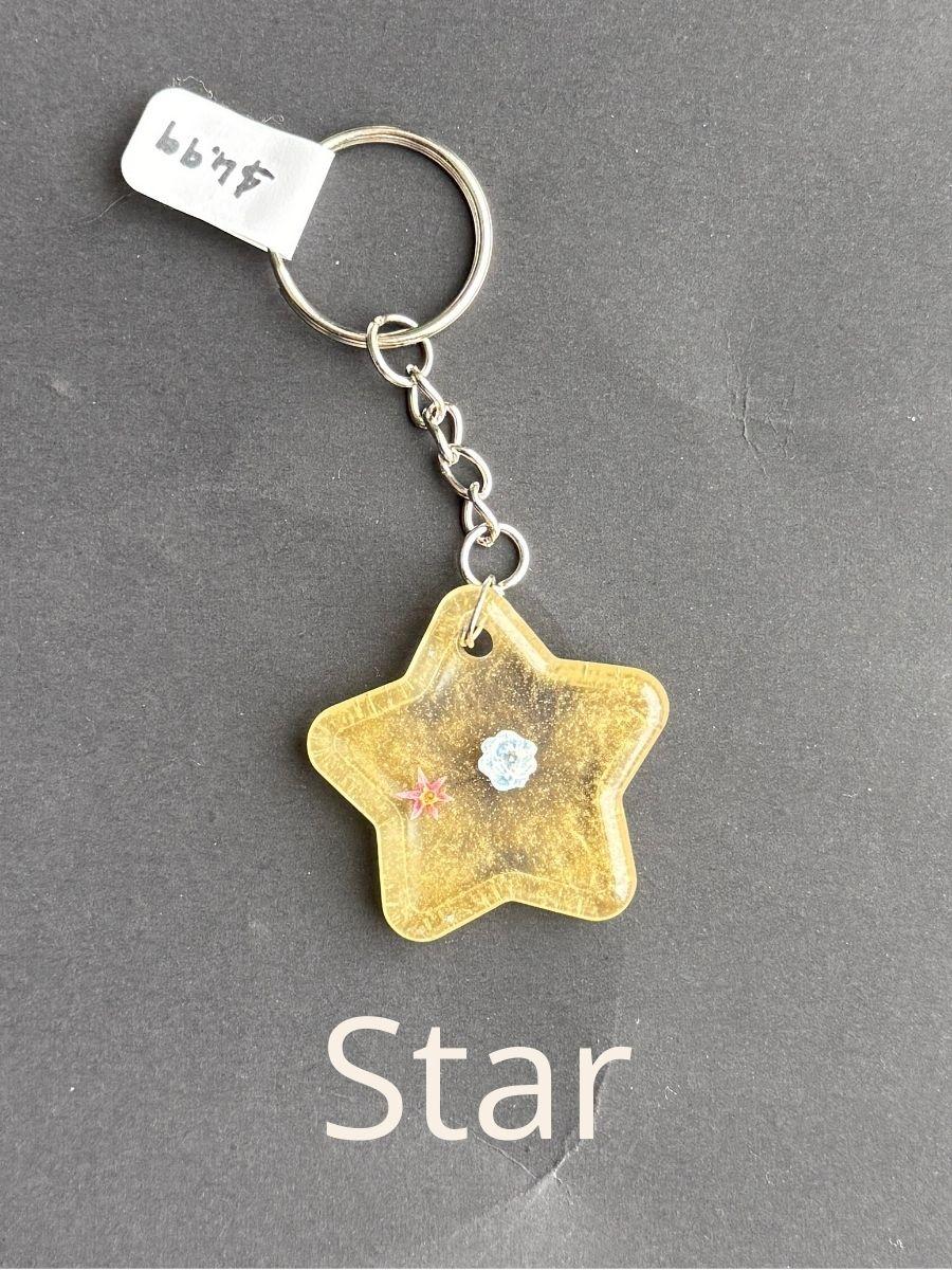 Star, keychain with floral design on a gray background
