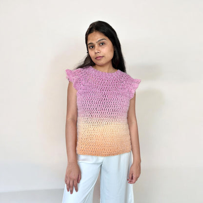 A girl wearing a crochet top-down blouse, highlighting the front design, neckline, and stitch pattern.