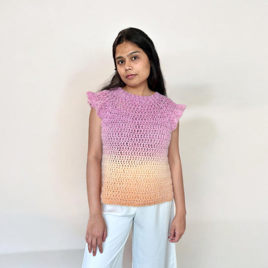 A girl wearing a crochet top-down blouse, highlighting the front design, neckline, and stitch pattern.